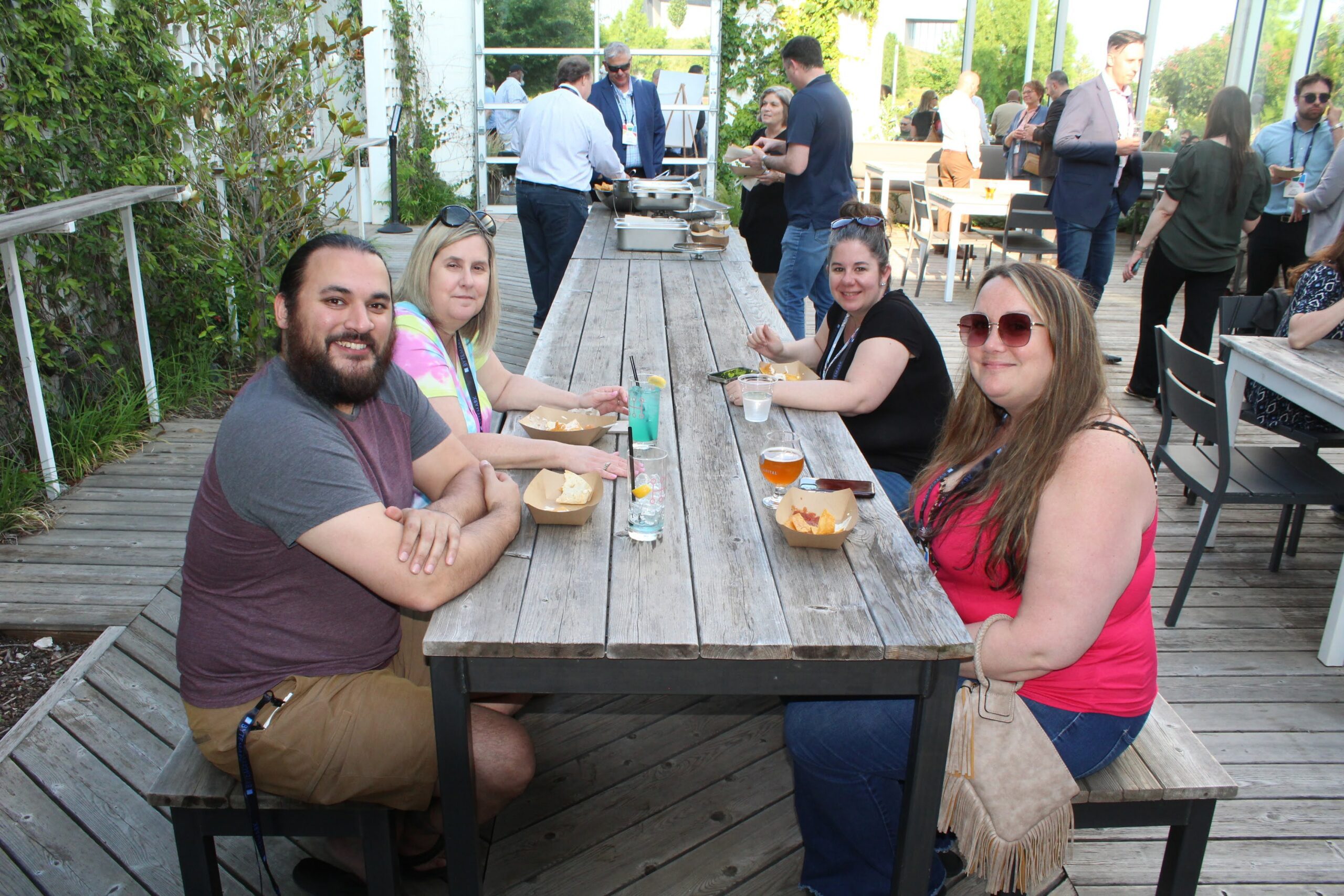 Attendees of the Social Capital evening event sitting at a long table in the courtyard.