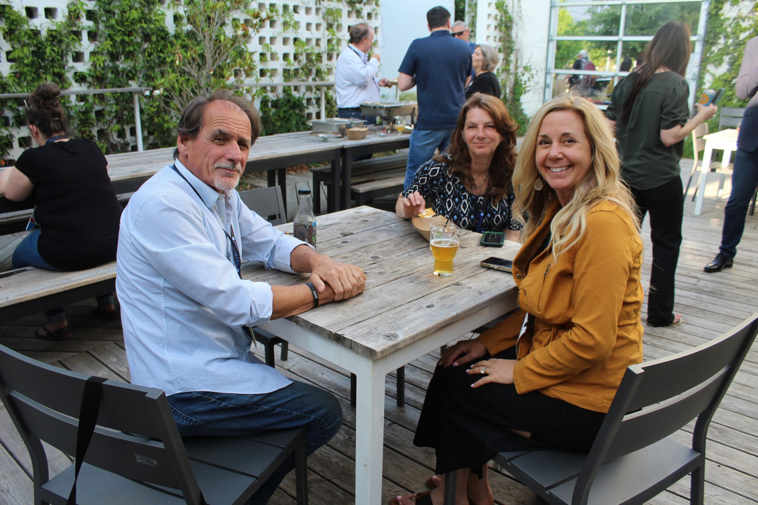 Attendees of the Social Capital evening event sitting together and enjoying beer in the courtyard.